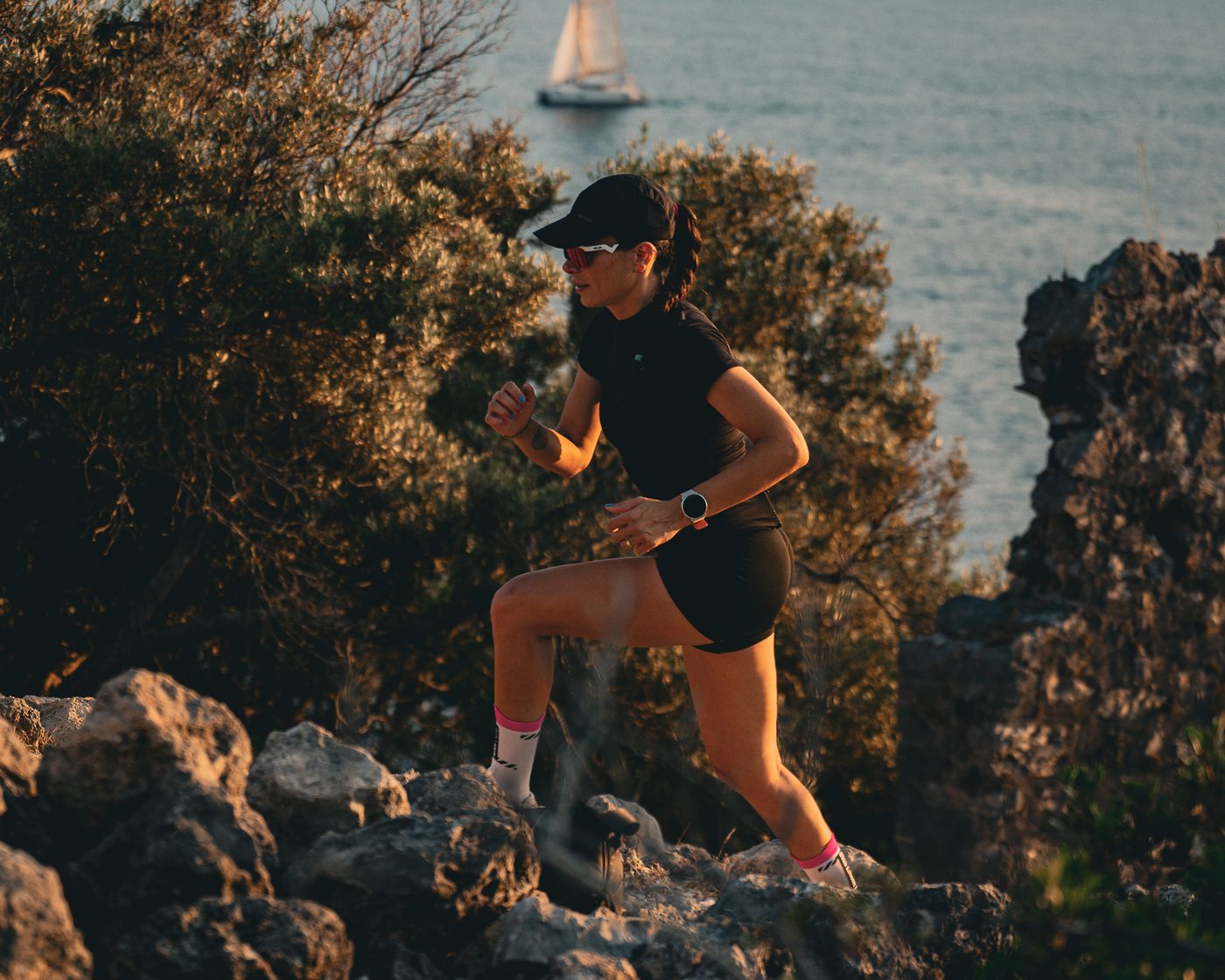 A runner on the rocks above the bay at Göcek, a yacht at anchor behind