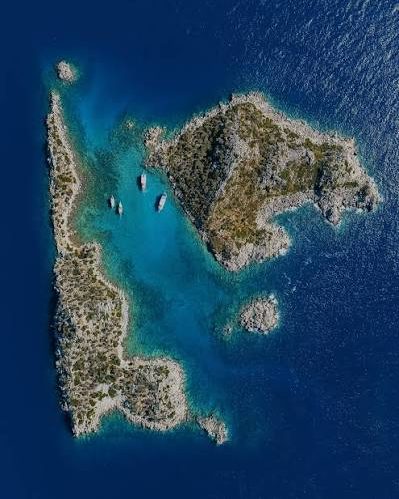 Akvaryum Bay from the air, a wooded islet in clear water