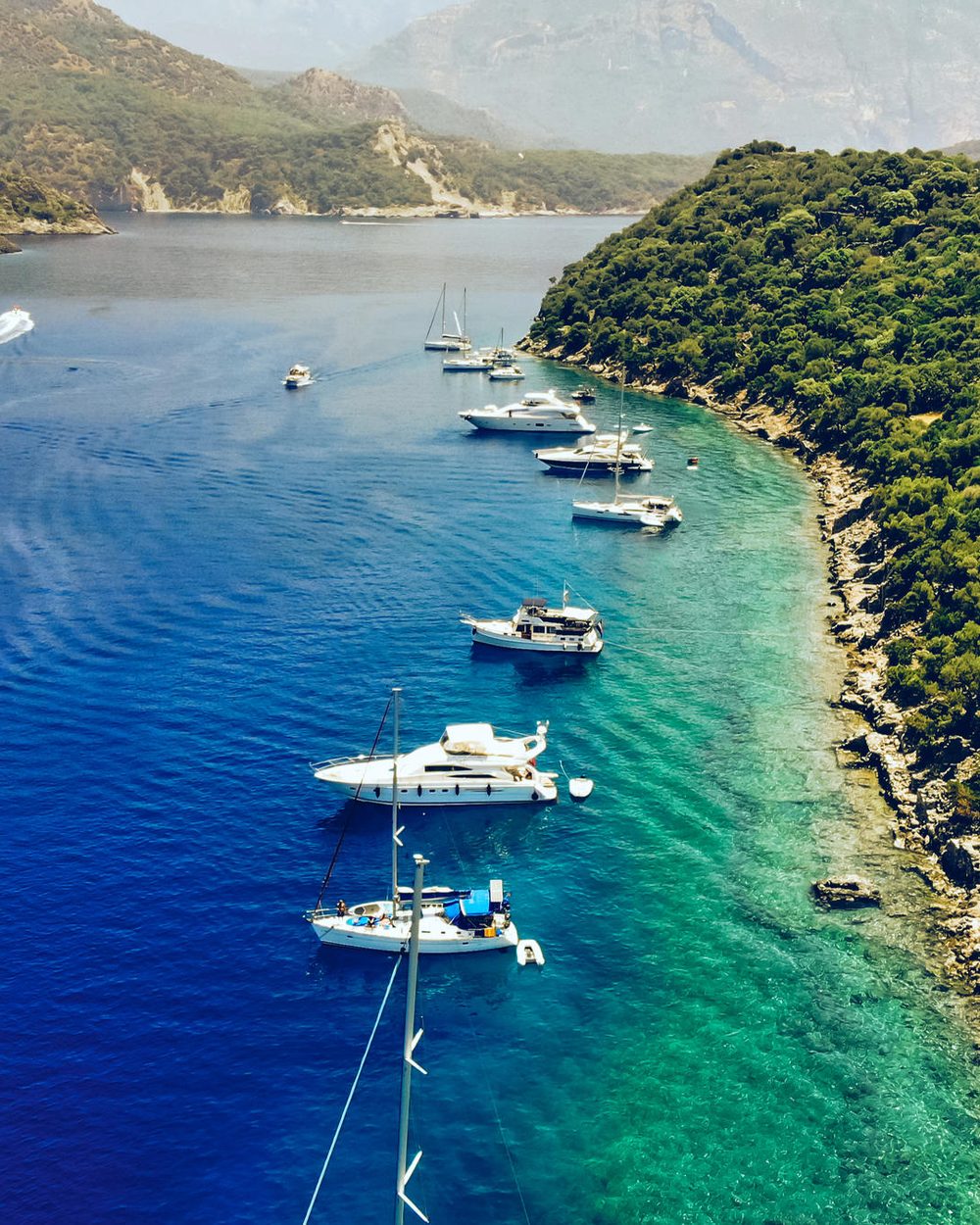 Gemiler Bay from the air, boats anchored under wooded slopes